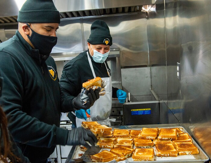 (Rick Egan | The Salt Lake Tribune)  Sid Burgos and Mike Youseff make grilled cheese sandwiches for 600 health care workers as part of the the Curds + Kindness program, which supports local dairy farmers, at the South Jordan Health Center in Daybreak on Tuesday, Dec. 1, 2020.