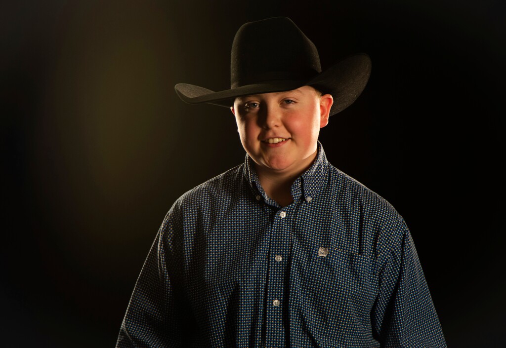 (Ben Dorger/Standard-Examiner via AP) In this April 19, 2018, photo, Thatch Elmer, 14-year-old emerging cowboy poet, poses for a photo at the Standard-Examiner. The Harrisville cowboy travels throughout the country to cowboy poetry events each year, causing him to miss about a month's worth of school days this year at Wahlquist Junior High where he's an eighth grader.