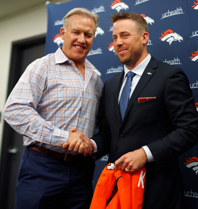 Denver Broncos general manager John Elway, left, shakes hands with Case Keenum during a news conference to introduce him as the new starting quarterback of the Broncos at the team's headquarters Friday, March 16, 2018, in Englewood, Colo. (AP Photo/David Zalubowski)