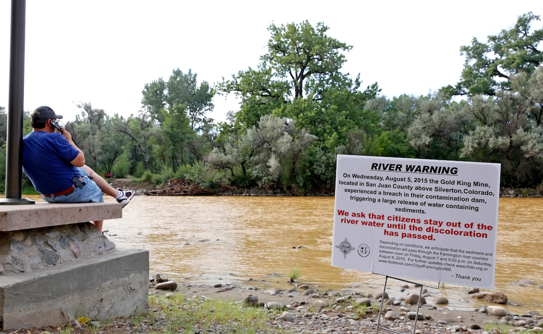 A warning sign from the city is displayed in front of the Animas River as orange sludge from a mine spill upstream flows past Berg Park in Farmington, N.M., Saturday, Aug. 8, 2015. About 1 million gallons of wastewater from Colorado's Gold King Mine began spilling into the Animas River on Wednesday when a cleanup crew supervised by the Environmental Protection Agency accidentally breached a debris dam that had formed inside the mine. The mine has been inactive since 1923. (Alexa Rogals/The Daily Times via AP)
