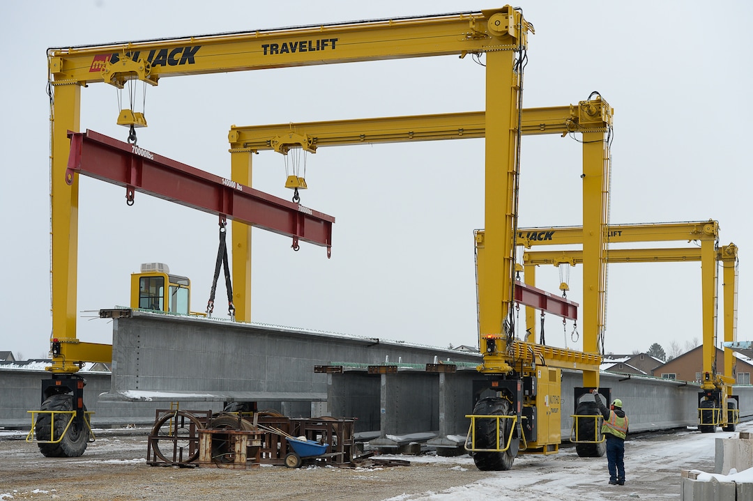 (Francisco Kjolseth  |  The Salt Lake Tribune)  UDOT gets ready to place some of the world's largest-ever bridge beams, and the largest in Utah state history with a span of 203 ft long and just over 8 ft tall, as crews use a special driving lift to load one on a truck following manufacturing at Forterra Structural Precast in Kearns on Tuesday, Dec. 11, 2018. A total of six beams will be installed in the technology corridor in Lehi later this week.
