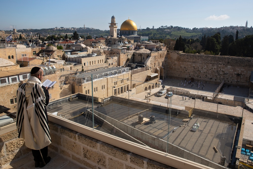 (Sebastian Scheiner | AP)An Israeli ultra-Orthodox Jewish man prays as others participate in the Cohanim priestly caste blessing during the Jewish holiday of Passover at the Western Wall, the holiest site where Jews can pray in Old Jerusalem on Sunday, April 12, 2020.