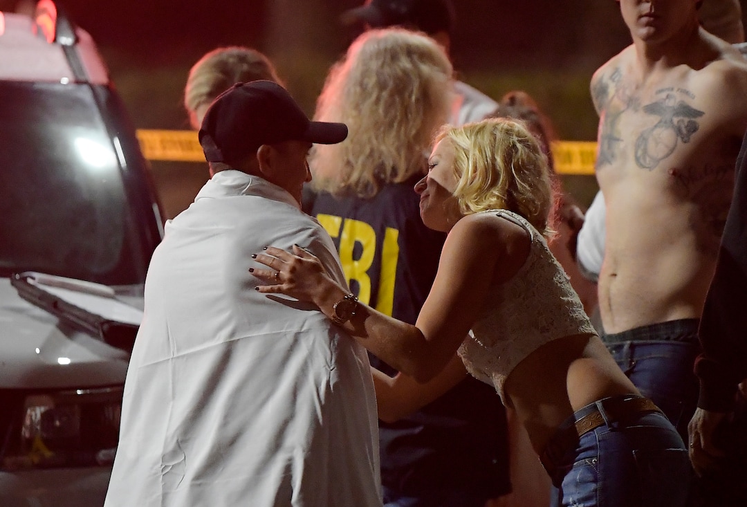 People comfort each other as they stand near the scene Thursday, Nov. 8, 2018, in Thousand Oaks, Calif. where a gunman opened fire Wednesday inside a country dance bar crowded with hundreds of people on "college night," wounding 11 people including a deputy who rushed to the scene. Ventura County sheriff's spokesman says gunman is dead inside the bar. (AP Photo/Mark J. Terrill)