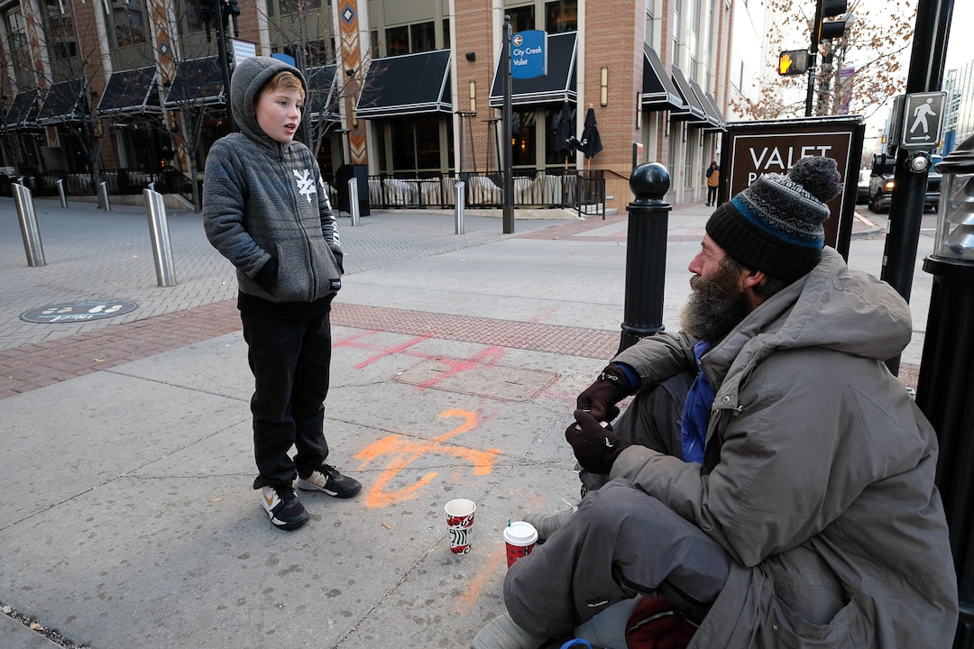 (Francisco Kjolseth  |  The Salt Lake Tribune) Ten-year-old Chase Hansen interviews Chris Coons, who is homeless, as he asks about his life and the things he misses most on Monday, Dec. 16, 2019. Chase who along with his father John have an organization called Project Empathy, spend time with people experiencing homelessness in an effort to connect with people on a personal level. On this occasion Chase learns that Coons used to be an electrician before losing much of his vision and how he loved to ski.