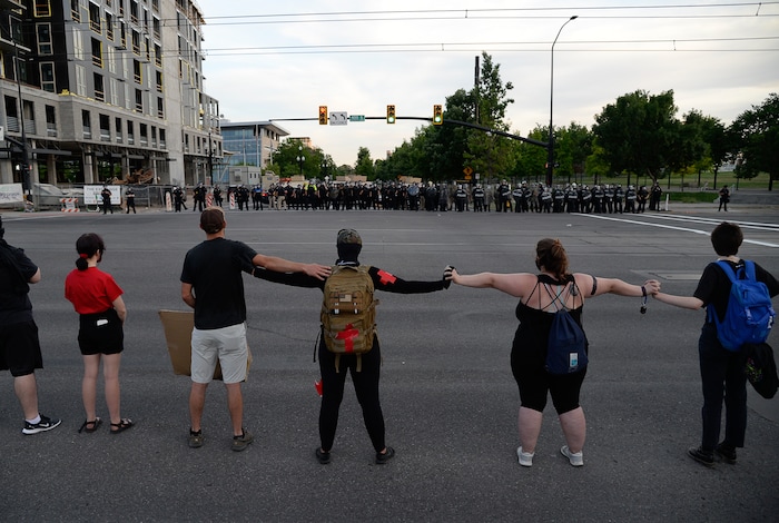 (Francisco Kjolseth  |  The Salt Lake Tribune) Police line up to enforce a mandatory curfew in Salt Lake City on Monday, June 1, 2020, as they get ready to push forward along 300 East near the downtown library following violence and unrest over the weekend due to the death of George Floyd by police.