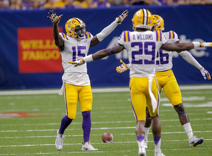 LSU cornerback Kary Vincent Jr. (15) celebrates with cornerback Andraez Williams (29) and safety John Battle (26) after breaking up a pass intended for BYU wide receiver Talon Shumway during the second half of an NCAA college football game in New Orleans, Saturday, Sept. 2, 2017. (AP Photo/Scott Threlkeld)