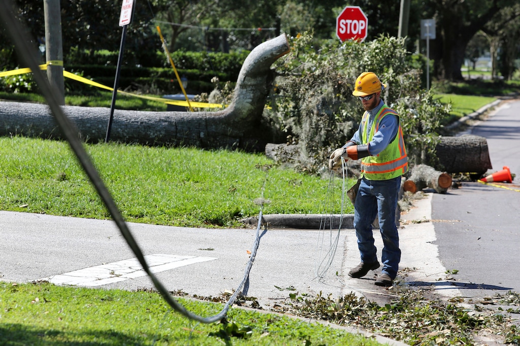 (Joe Burbank | Orlando Sentinel via AP) A Duke Energy contractor coils downed power lines along Dommerich Drive during the first stage of assessment and restoration in the aftermath of Hurricane Irma, Wednesday, Sept. 13, 2017, in Maitand, Fla. The storm dragged down power lines and blew out transformers knocking out power to millions across Florida.