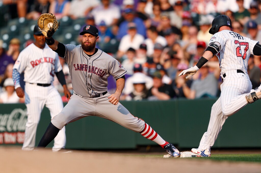 Colorado Rockies' Trevor Story, right, beats the throw to San Francisco Giants first baseman Brandon Belt for an infield single during the first inning of a baseball game Wednesday, July 4, 2018, in Denver. (AP Photo/David Zalubowski)