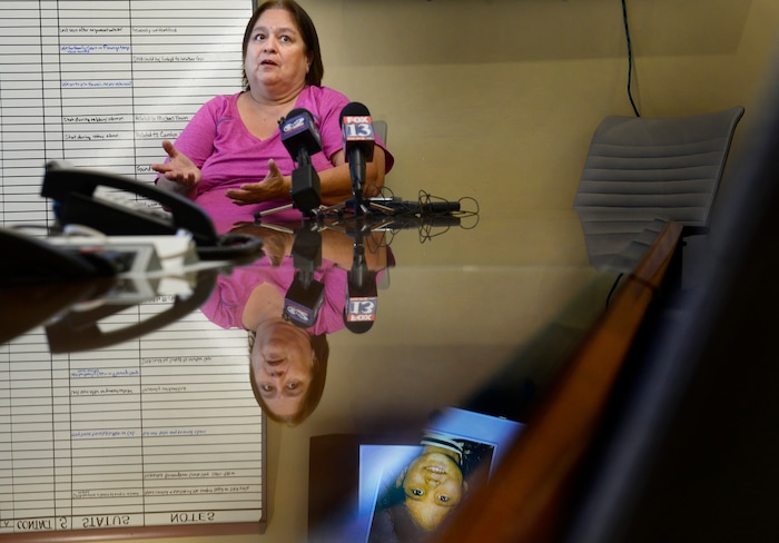 (Scott Sommerdorf   |  The Salt Lake Tribune)   
Lewine Tapia, the mother of cold case victim Rosie Tapia, whose photo is reflected in the table, below, speaks about proposed legislation, nicknamed "Rosie's Bill," that would lobby for a centralized database for all cold cases in the state, during a press conference with the Utah Cold Case Coalition, Thursday, January 18, 2018.