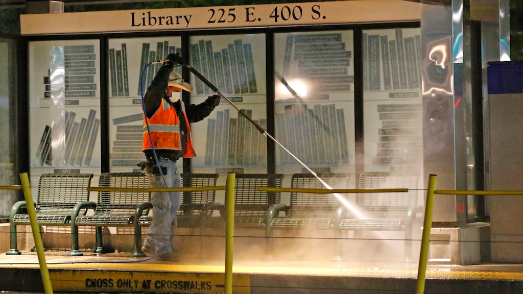 Utah Transit Authority personnel clean and disinfect a train station to prevent the spread of the coronavirus virus Friday, April 17, 2020, in Salt Lake City. Crews are sent out daily to clean and disinfect all rail stations, including all surfaces that are frequently touched.  (AP Photo/Rick Bowmer)