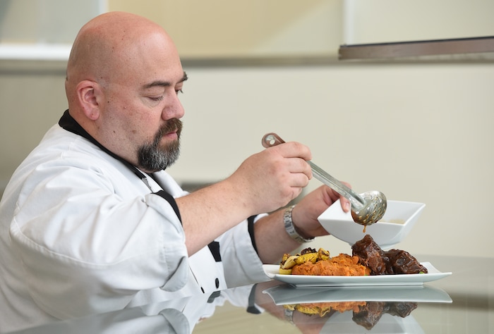 (Francisco Kjolseth  |  The Salt Lake Tribune)  Executive Chef Steve Ulibarri of Cuisine Unlimited, puts the finishing touches on braised beef short ribs, one of several "Hamilton" era-inspired dishes that will be served at the Eccles Theater during the run of "Hamilton."