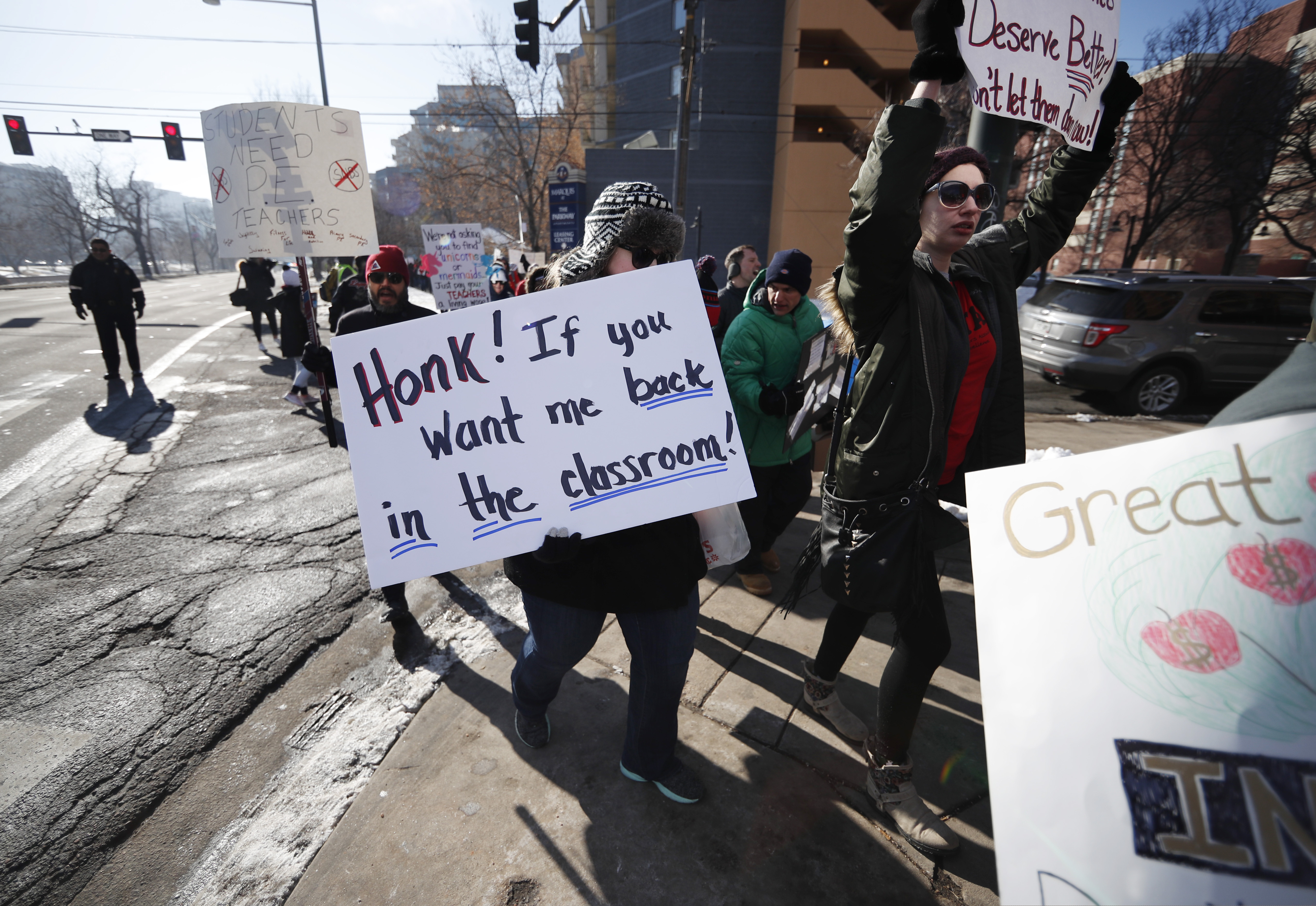 Teachers carry placards as they march along Speer Boulevard from West High School Monday, Feb. 11, 2019, in Denver. Denver teachers went on strike Monday after failing to reach a deal with administrators on pay in the latest example of educator discontent, following a wave of walkouts over the last year. (AP Photo/David Zalubowski)