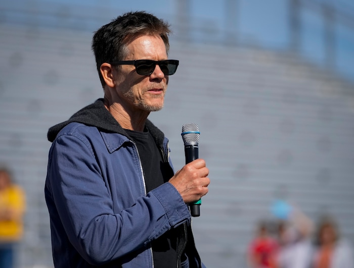 (Bethany Baker | The Salt Lake Tribune) Kevin Bacon speaks at a charity event to commemorate the 40th anniversary of the movie "Footloose" on the football field of Payson High School in Payson on Saturday, April 20, 2024.