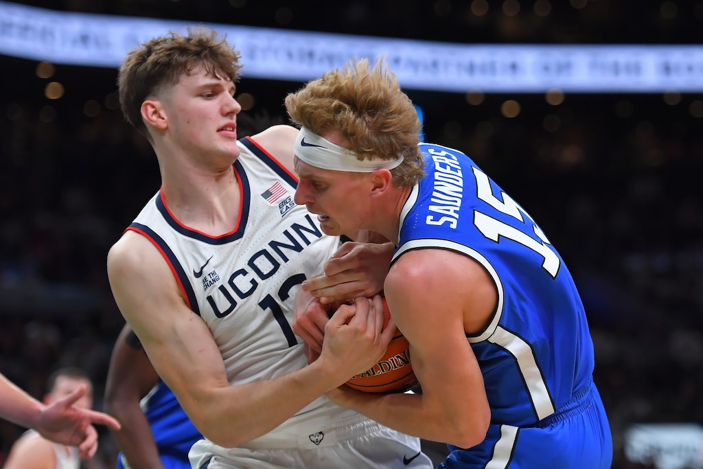 (Steven Senne | AP) UConn center Eric Reibe and BYU guard Richie Saunders grapple for control of the ball in the first half of an NCAA college basketball game, Saturday, Nov. 15, 2025, in Boston.