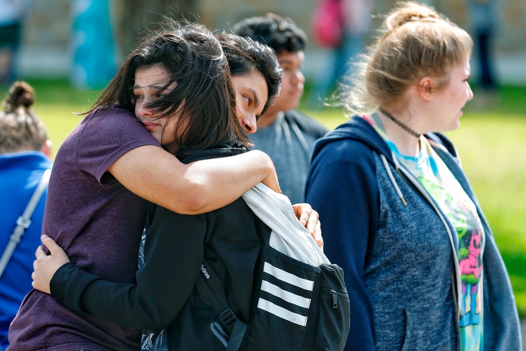 Santa Fe High School freshman Caitlyn Girouard, center, hugs her friend outside the Alamo Gym where students and parents wait to reunite following a shooting at Santa Fe High School Friday, May 18, 2018, in Santa Fe, Texas. (Michael Ciaglo/Houston Chronicle via AP)
