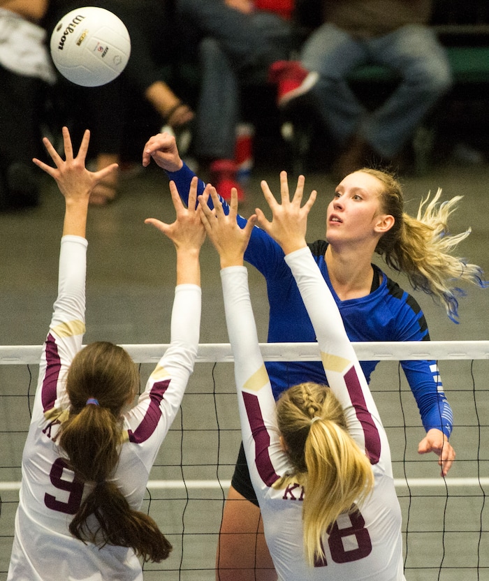 (Rick Egan  |  The Salt Lake Tribune)   Pleasant Grove Vikings Heather Gneiting (5) hits the ball, as Pleasant Grove Vikings Lone Peak Knights  Madelyn Robinson (9) and Megan Sintay (18) defend, in 6A volleyball championship action, Pleasant Grove vs. Lone Peak, at Utah Valley University, Saturday, November 4, 2017.