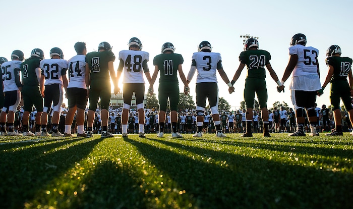 (Chris Detrick  |  The Salt Lake Tribune)    Members of the Hillcrest and Highland football teams hold hands during a remembrance for Hillcrest football coach Cazzie Brown before the game at Hillcrest High School Friday, September 1, 2017. Cazzie Brown passed away Sunday night after spending four days in the hospital. According to a family representative, Brown was brought to the emergency room Wednesday for complications with his thyroid. The doctors found that he had contracted meningitis, and later received a preliminary positive after being tested for West Nile virus. 