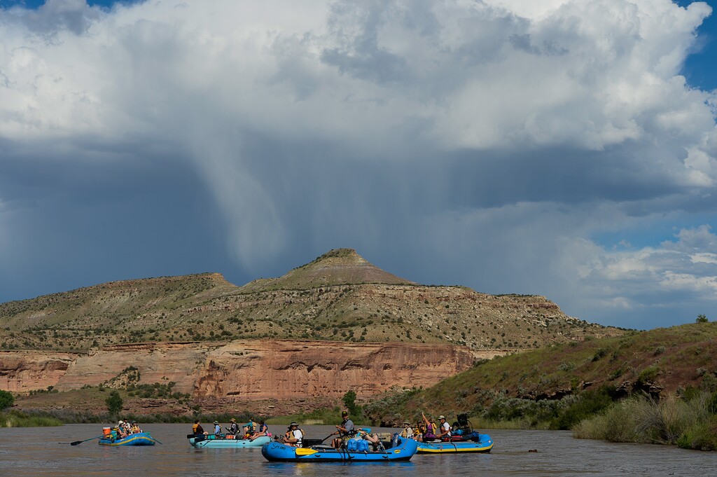 (Francisco Kjolseth  |  Tribune file photo) A distant thunder cloud provides a dramatic backdrop as a group from SPLORE floats down the Colorado River recently during a three-day trip. New data from the Outdoor Industry Association (OIA) indicates Utahns spend more than $7 billion each year on outdoor recreation.
