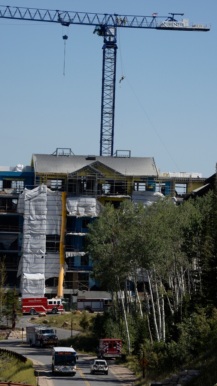 (Scott Sommerdorf | The Salt Lake Tribune) A firefighter with the Park City Fire District is lowered to the ground from the top of the 200-foot Jacobsen tower crane while conducting a high mountain rescue training exercise utilizing a Jacobsen tower crane at site of the One Empire Pass development at Deer Valley, Sunday, Aug. 20, 2017.