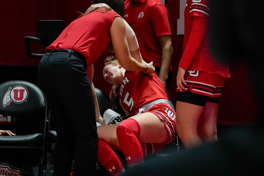 (Francisco Kjolseth | The Salt Lake Tribune) Utah Utes guard Gianna Kneepkens (5) collapses onto the team bench after being helped off the court after breaking multiple bones in her foot during the end of game play against BYU in NCAA basketball at the Huntsman Center in Salt Lake City on Saturday, Dec. 2, 2023.