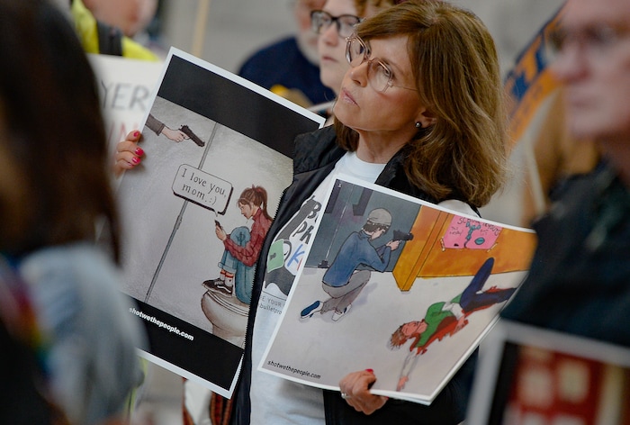 (Francisco Kjolseth  |  The Salt Lake Tribune) Artwork depicting gun violence created by students is displayed by Claudia Fruin of the group Bulletproof Kids Utah as she attends a rally at the Utah Capitol for a mid-session report on the progress of gun violence and public safety bills in the Utah Legislature on Saturday, Feb. 15, 2020. The rally took place the day after the anniversary of the shooting at Stoneman Douglas high school in Parkland, FL.