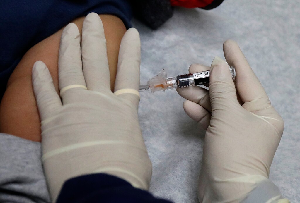 (Ted S. Warren | The Associated Press) In this Jan. 12, 2018, file photo, Ana Martinez, a medical assistant at the Sea Mar Community Health Center, gives a patient a flu shot in Seattle. Researchers found in a study of credit reports that more than 2 percent of adults had medical bills under $200 sent to a collections agency. More than half of the annual medical collections were for less than $600, according to the study, which examined 2016 credit reports for more than 4 million unidentified people.