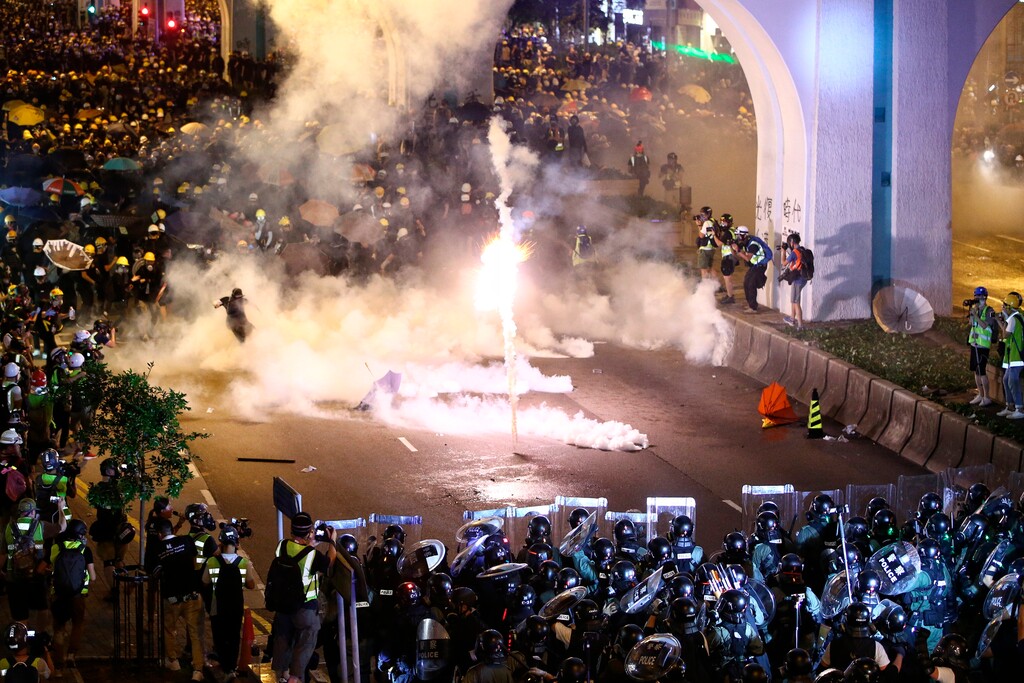 Protesters are engulfed by teargas during a confrontation with riot police in Hong Kong Sunday, July 21, 2019. Hong Kong police launched tear gas at protesters Sunday after a massive pro-democracy march continued late into the evening. The action was the latest confrontation between police and demonstrators who have taken to the streets to protest an extradition bill and call for electoral reforms in the Chinese territory. (Lo Kwanho/HK01 via AP)