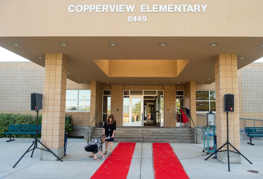 (Rick Egan  |  The Salt Lake Tribune)         Jeri Rigby, the new principal of Copperview Elementary School, tapes down the red carpet, with a little help from Tonya Rhodes,  at Copperview Elementary, on the first day of school, Monday, Aug. 19, 2019.