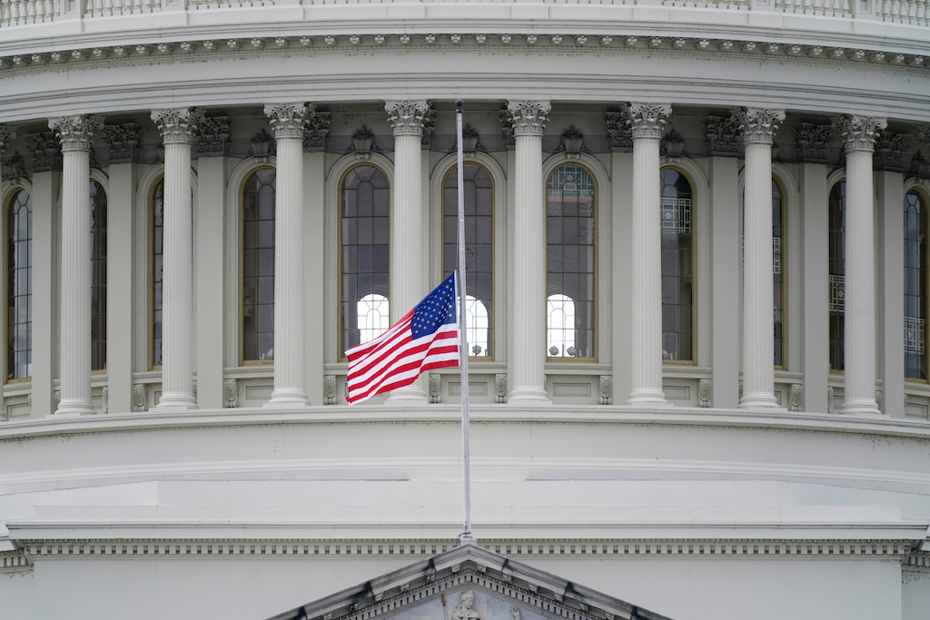 An American flag flies at half-staff in remembrance of U.S. Capitol Police Officer Brian Sicknick above the Capitol Building in Washington, Friday, Jan. 8, 2021. Sicknick died from injuries sustained as President Donald Trump's supporters stormed the Capitol. (AP Photo/Patrick Semansky)