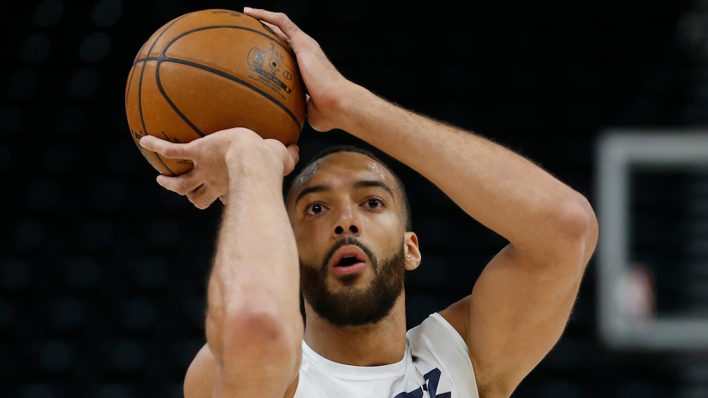 FILE - In this Feb. 24, 2020, file photo, Utah Jazz center Rudy Gobert shoots during practice before a NBA basketball game against the Phoenix Suns in Salt Lake City. Gobert is standing tall, even after having coronavirus and dealing with an enormous amount of scorn after being diagnosed. He was the first NBA player to test positive for the virus and that prompted many to blame him for the league's shutdown in response to the pandemic. (AP Photo/Rick Bowmer, File)