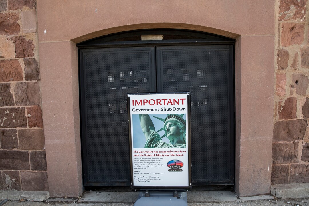 An advertisement for a cruise around the Statue of Liberty and Ellis Island is placed at the entrance to Castle Clinton, Saturday, Jan. 20, 2018, in New York. The National Park Service announced that the Statue of Liberty and Ellis Island would be closed Saturday "due to a lapse in appropriations." Late Friday, the Senate failed to approve legislation to keep the government from shutting down after the midnight deadline. (AP Photo/Mary Altaffer)