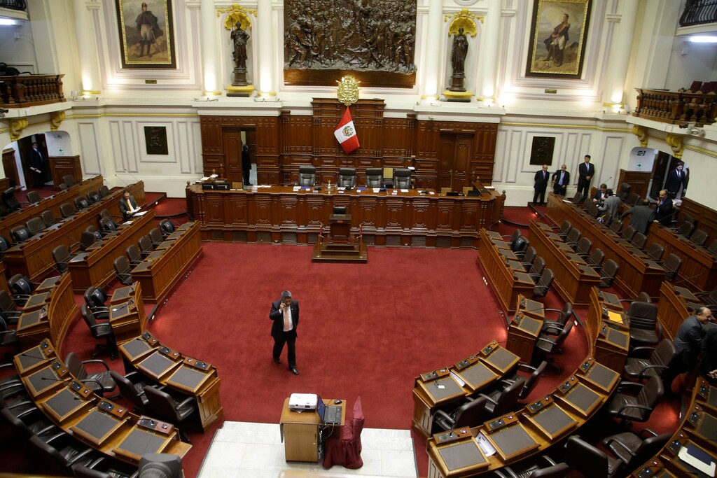 A congressman paces the empty congressional chamber while on his phone as he waits the start of a vote on whether to initiate impeachment proceeding against the country's president, in Lima, Peru, Friday, Dec. 15, 2017. Opponents demanded President Pedro Pablo Kucyznski resign over revelations of decade-old payments from Odebrecht, a Brazilian construction company, at the center of Latin America's biggest graft scandal. (AP Photo/Martin Mejia)