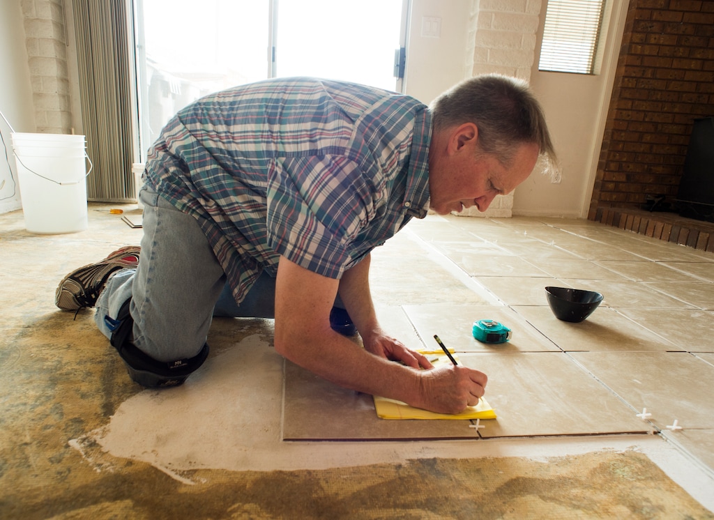 (Rick Egan  |  The Salt Lake Tribune) Ken Peterson lays tile in his home in St. George, Utah, as he prepares for the chance that he'll need to put his house on the market. Peterson taught music at Dixie State University and was preparing some students for their senior recitals when he was put on leave in the middle of the semester last month.
