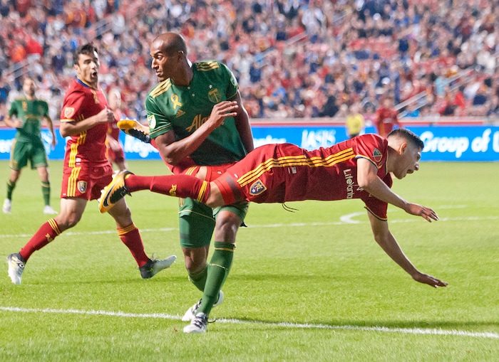 (Michael Mangum  |  Special to the Tribune)  Real Salt Lake forward Jefferson Savarino (7) flies to the pitch in front of Portland Timbers defender Roy Miller (7) during their MLS match at Rio Tinto Stadium in Sandy, UT on Saturday, September 16, 2017.