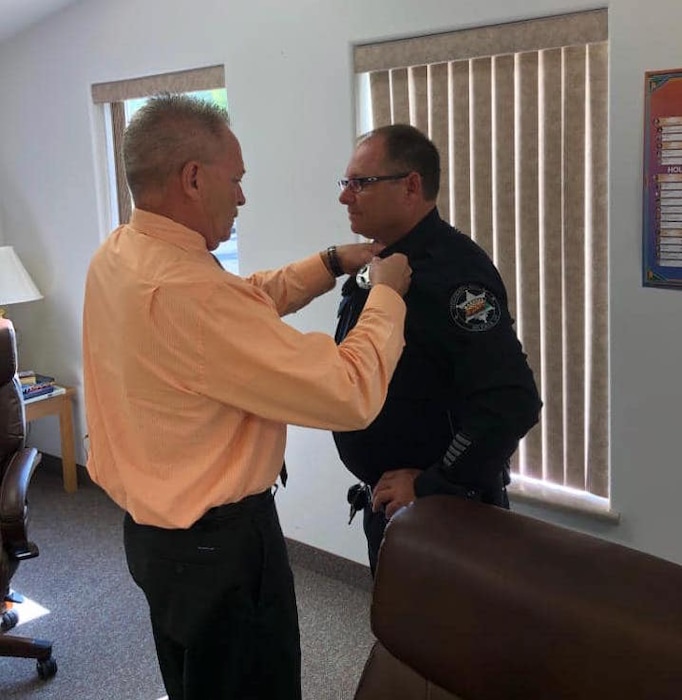 (Photo courtesy Hildale municipal government) Jim Keith, left, pins chief insignia on Robb Radley after he is sworn in as chief marshal of Hildale, Utah, and Colorado City, Ariz., in August 2019. Radley was injured this week by a domestic-violence suspect.