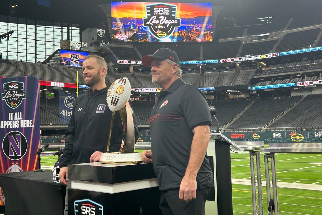 (Eric Walden  |  The Salt Lake Tribune) Utah football coach Kyle Whittingham (right) and Northwestern coach David Braun pose with the Las Vegas Bowl trophy during a media session at Allegiant Stadium on Friday, Dec. 22, 2023.