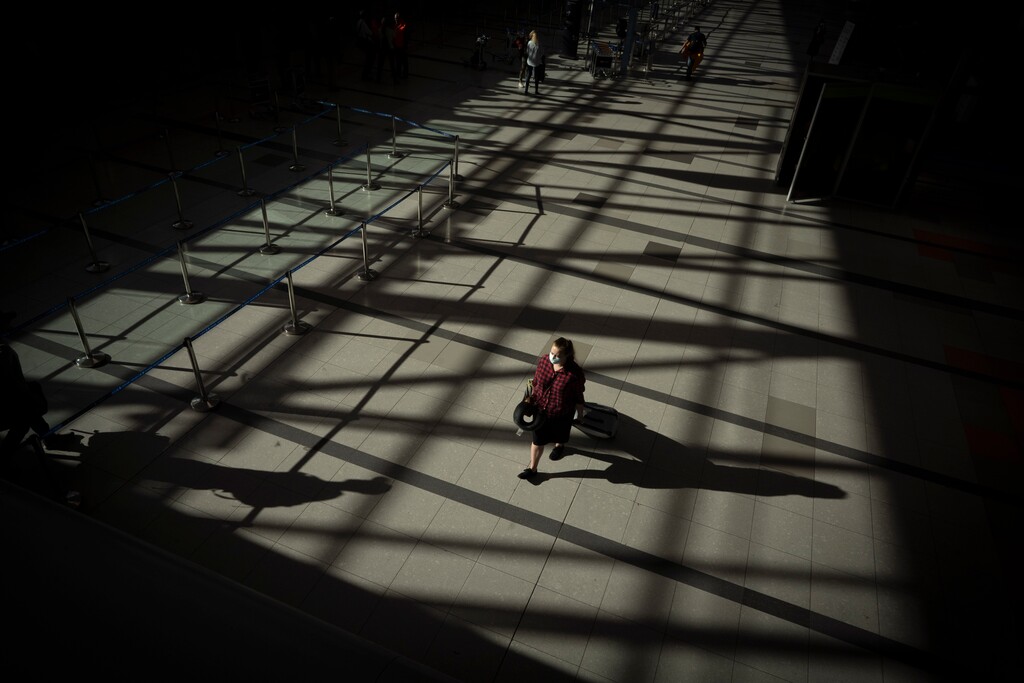 (Victor R. Caivano | AP)  A passenger walks through an empty terminal at Ezeiza International Airport in Buenos Aires, Argentina, Monday, March 23, 2020. Most flights have been canceled to help stop the spread of the new coronavirus.