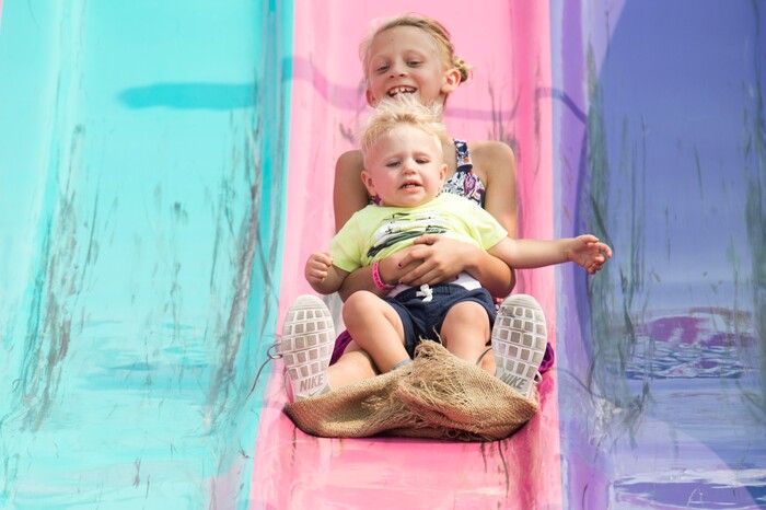 (Rick Egan  |  The Salt Lake Tribune)    Abigail Jensen 9, rides down the Fun Slide with her little brother Ezra, 11/2,  at the Davis County Fair in Farmington, Saturday, Aug. 18, 2018.