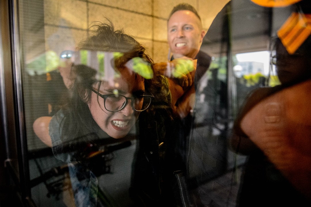 (Trent Nelson  |  The Salt Lake Tribune) Police take a woman into custody while removing protesters occupying the Chamber of Commerce Building Salt Lake City on Tuesday, July 9, 2019. Dozens of people showed up to protest the proposed Inland Port and ended up clashing with police, resulting in temporary street closures and arrests.