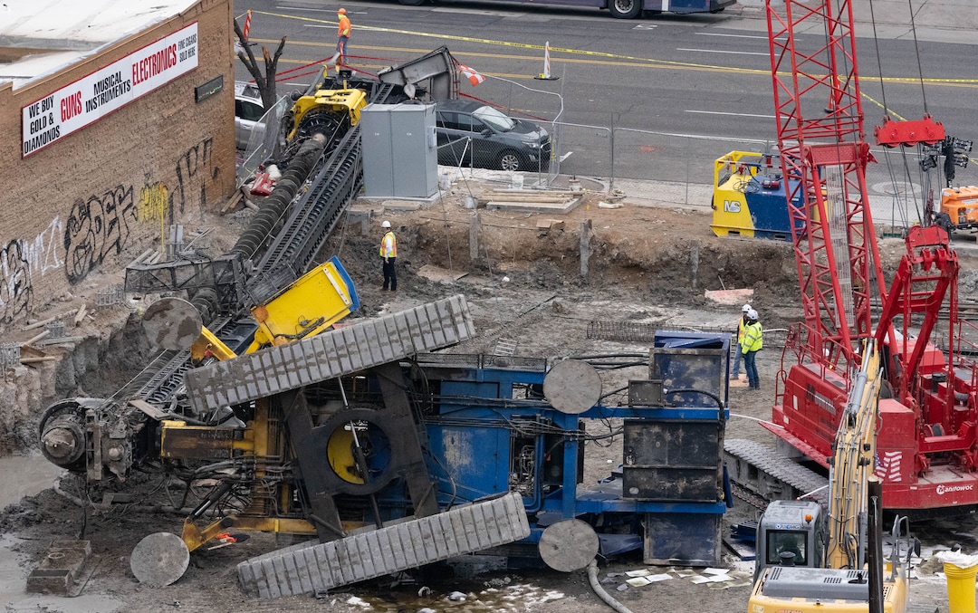 (Francisco Kjolseth | The Salt Lake Tribune) Crews survey the damage of a collapsed drill rig as seen on Wednesday, March 16, 2022, at the intersection of State Street and 200 South. The rig toppled over Tuesday night at the site of the new Astra Tower, crushing two unoccupied parked cars and sending the crane operator to the hospital in serious condition.