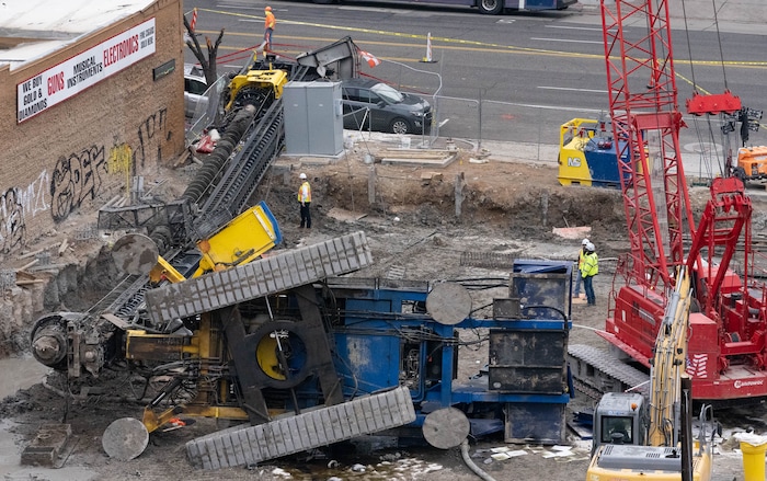 (Francisco Kjolseth | The Salt Lake Tribune) Crews survey the damage of a collapsed drill rig as seen on Wednesday, March 16, 2022, at the intersection of State Street and 200 South. The rig toppled over Tuesday night at the site of the new Astra Tower, crushing two unoccupied parked cars and sending the crane operator to the hospital in serious condition.