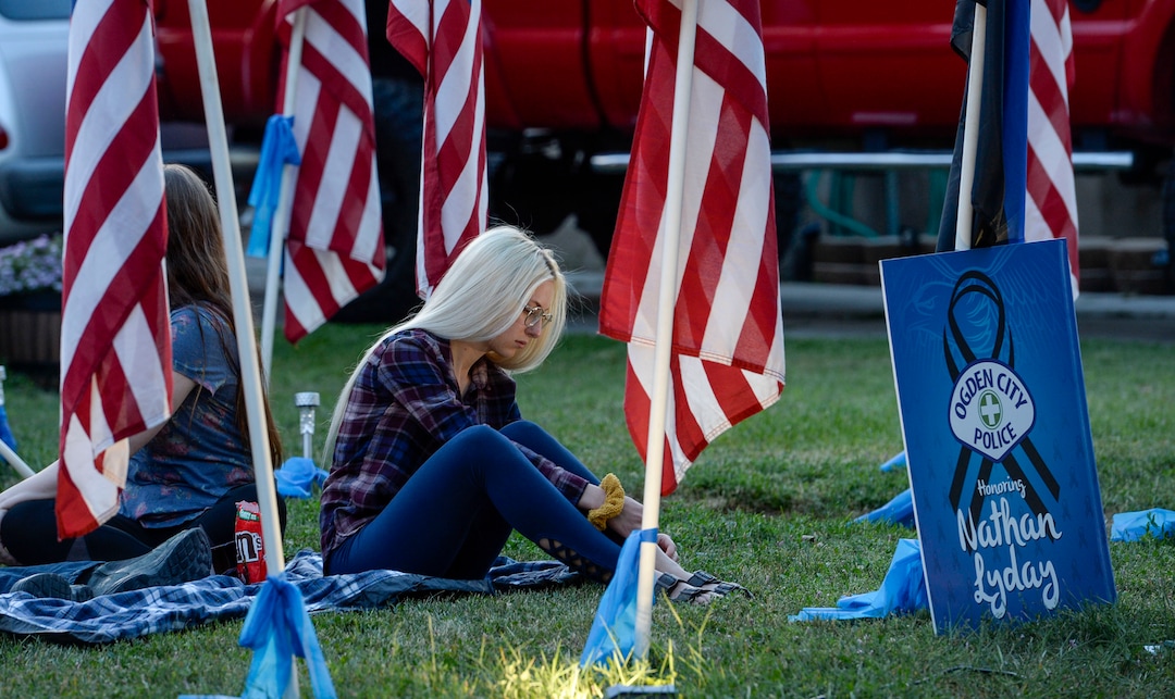 (Leah Hogsten  |  The Salt Lake Tribune) Officer Nate Lyday's cousin Jacquelyn Mesmer sits with family in the front yard of Lyday's mother's home.  Friends and supporters lined the neighborhood of Officer Nate Lyday's childhood home on Custer Avenue in Ogden prior to the Memorial Procession and Community Vigil in honor of Lyday's life. The procession made its way through five other Ogden landmarks before ending at Lindquist Field.