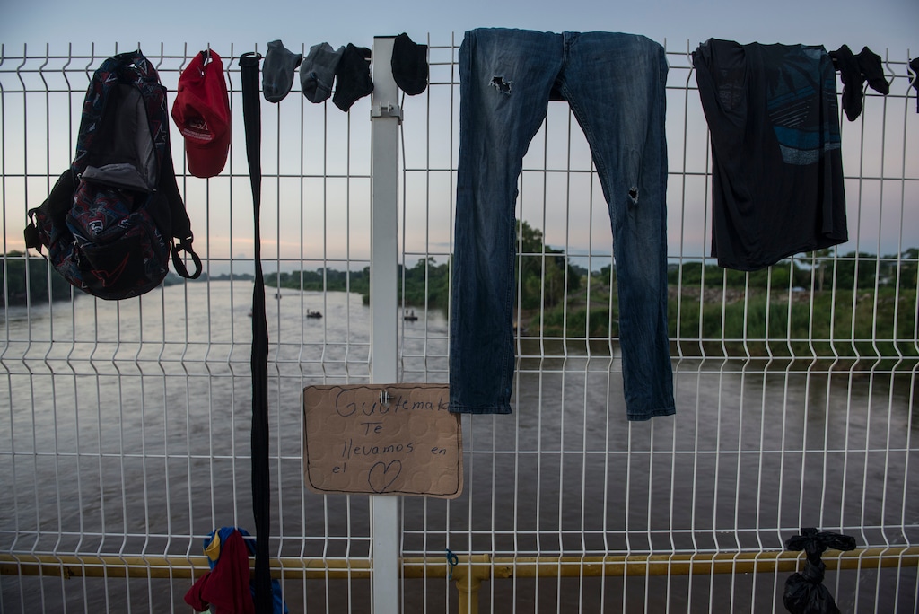 (Oliver de Ros | The Associated Press) Clothes belonging to a Honduran migrant hangs to dry on the fence of a border bridge that stretches over the Suchiate River, connecting Guatemala and Mexico, in Tecun Uman, Guatemala, Monday, Oct. 22, 2018. Hundreds of migrants, who are part of a caravan bound for the U.S.-Mexico border are waiting on the border bridge to be attended by Mexican immigration authorities.