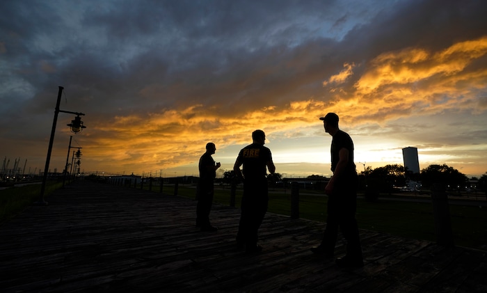 Port Arthur firefighters stare at a sea wall at sunset as they wait for Hurricane Laura to make landfall, Wednesday, Aug. 26, 2020, in Port Arthur, Texas. (AP Photo/Eric Gay)