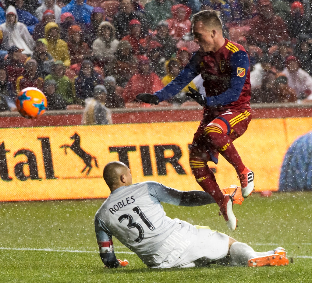 (Rick Egan  |  The Salt Lake Tribune)      Real Salt Lake forward Corey Baird (27) flies over the top of New York Red Bulls goalkeeper Luis Robles (31), in MLS action between Real Salt Lake and New York Red Bulls at Rio Tinto Stadium, Saturday, March 17, 2018.
