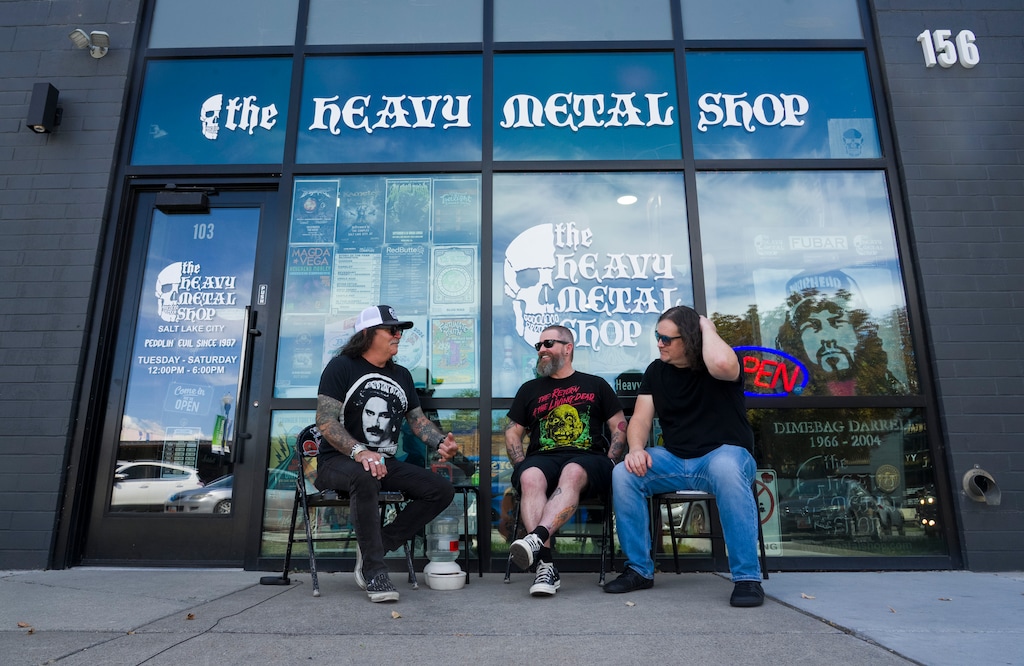(Bethany Baker | The Salt Lake Tribune) The Heavy Metal Shop owner Kevin Kirk, left, sits beside Allen Martindale, center, and Brannon Richardson, a documentary director and producer combo who are working on an upcoming documentary about The Heavy Metal Shop, seen here outside the business in Salt Lake City on Tuesday, Aug. 25, 2026.