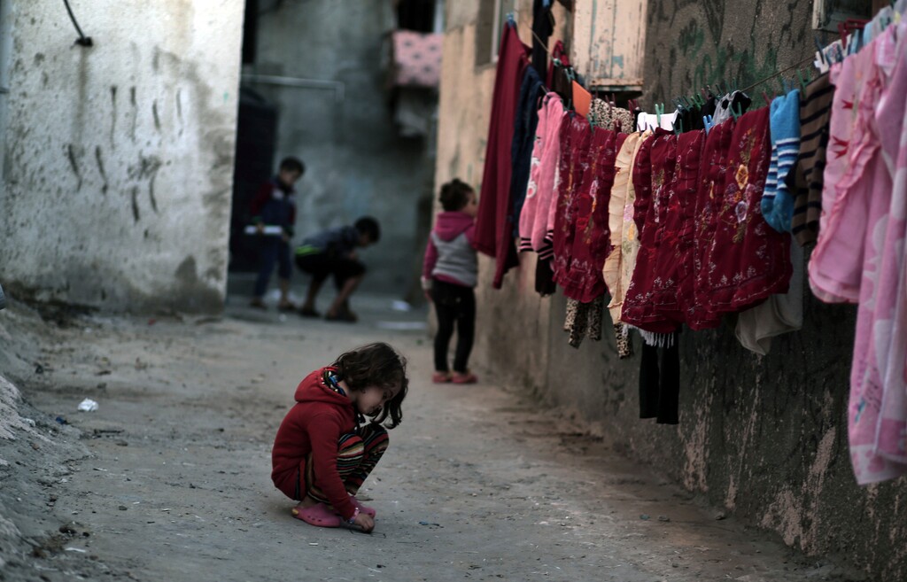 In this Thursday Jan. 11, 2018 photo, Palestinian children play in an alley at the Shati refugee camp in Gaza City. From the Gaza Strip to Jordan and Lebanon, millions of Palestinians are bracing for the worst as the Trump administration moves toward cutting funding to the U.N. agency that assists Palestinian refugees across the region. The expected cuts could deliver a painful blow to some of the weakest populations in the Middle East and risk destabilizing the already struggling countries that host displaced Palestinian refugees and their descendants. (AP Photo/ Khalil Hamra)