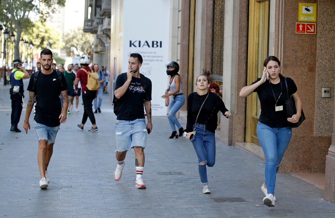 (Manu Fernandez | The Associated Press) People run down a street in Barcelona, Spain, Thursday, Aug. 17, 2017. Police in the northern Spanish city of Barcelona say a white van has jumped the sidewalk in the city's historic Las Ramblas district, injuring several people.