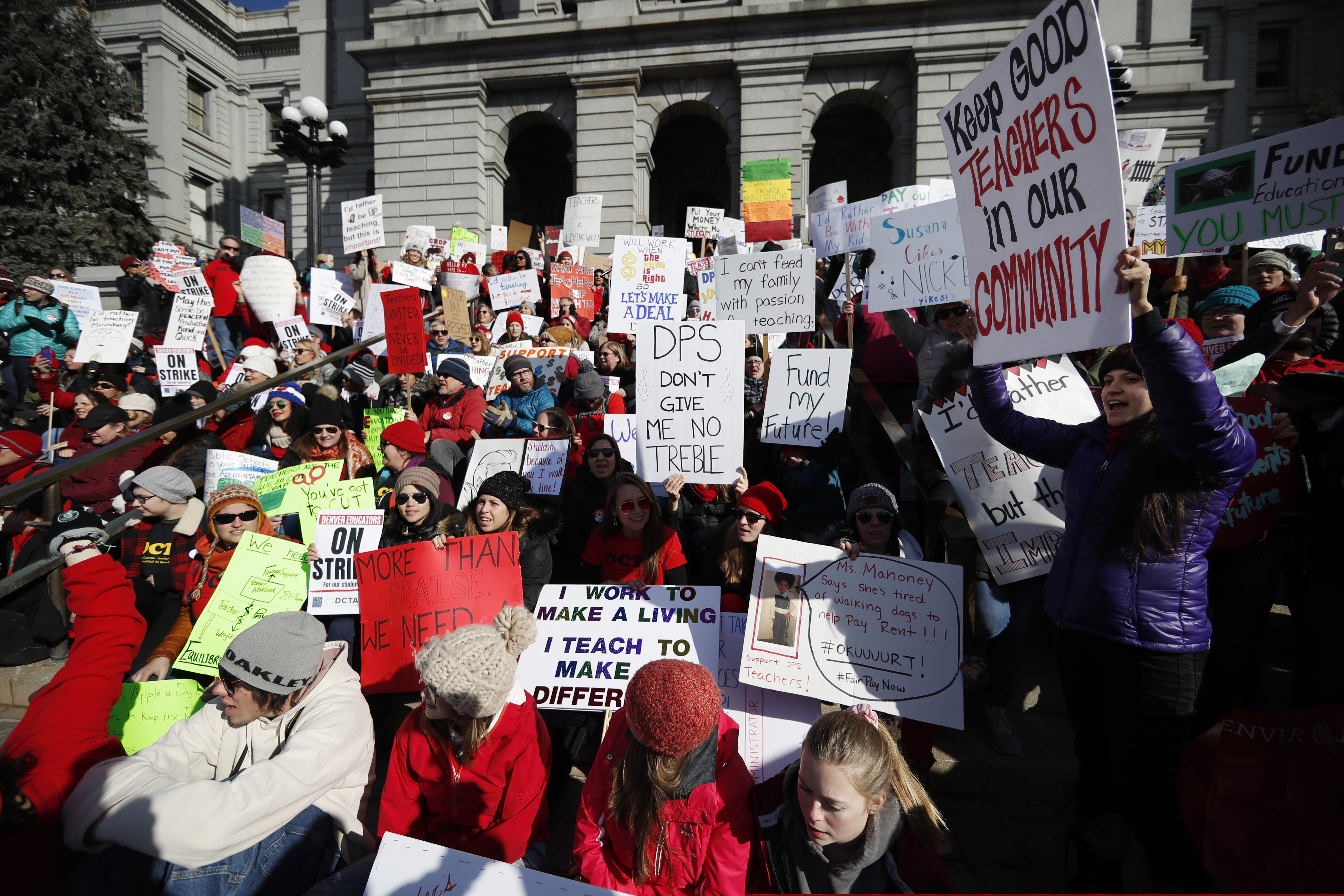 Teachers wave placards during a strike rally on the west steps of the state Capitol, Monday, Feb. 11, 2019, in Denver. The strike is the first for teachers in Denver since 1994 and centers on base pay. (AP Photo/David Zalubowski)