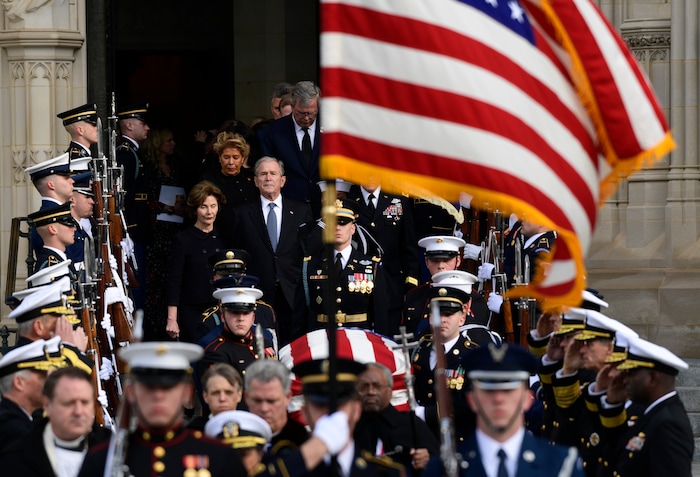Former President George W. Bush and his wife Laura Bush, center left, join their family as they follow the casket of former President George H.W. Bush as it is carried out after a State Funeral at the National Cathedral in Washington, Wednesday, Dec. 5, 2018. (AP Photo/Susan Walsh)